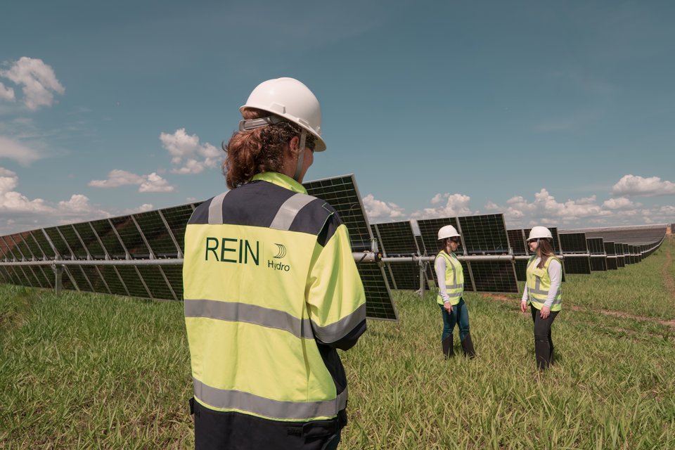 a group of people wearing hardhats and standing in a field a group of people wearing hardhats and standing in a field