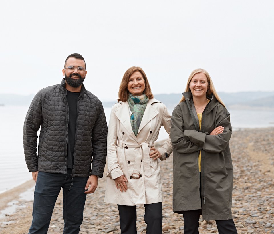 a group of people posing for a photo on a beach a group of people posing for a photo on a beach